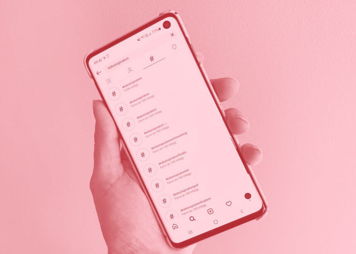 En hand som håller i en smartphone som visar en sökresultatskärm med hashtags. Bakgrunden och bilden har en rosa nyans.